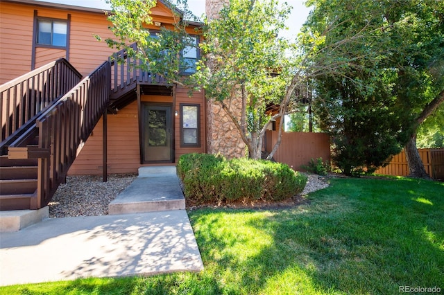 doorway to property with a yard and fence