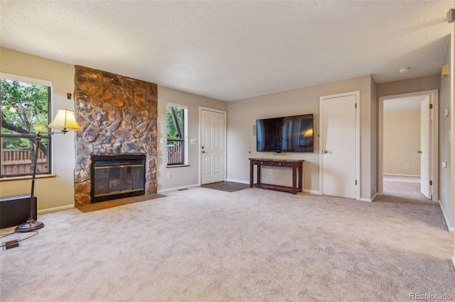 unfurnished living room with carpet floors, a healthy amount of sunlight, a fireplace, and a textured ceiling