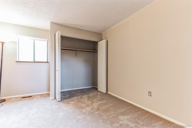 unfurnished bedroom featuring carpet floors, a closet, visible vents, and baseboards