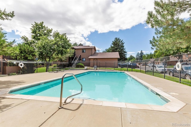 pool with a patio area and fence