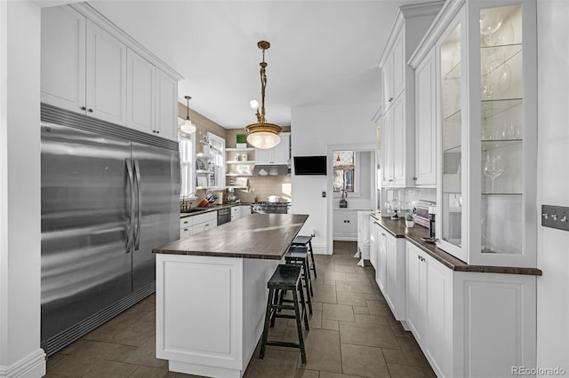 kitchen featuring open shelves, appliances with stainless steel finishes, white cabinets, and decorative backsplash