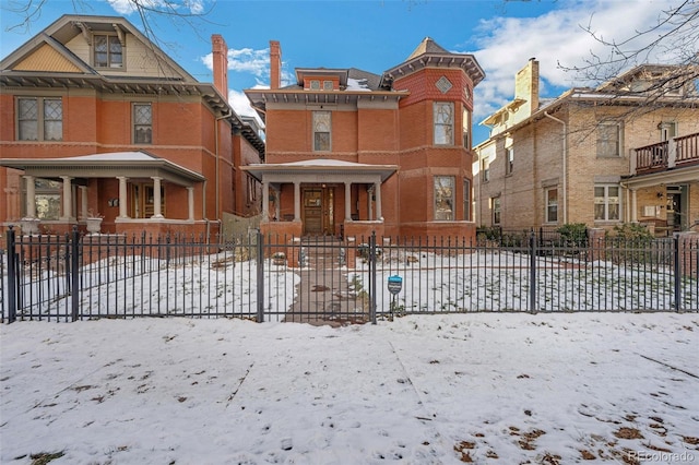 view of front of house featuring brick siding and fence