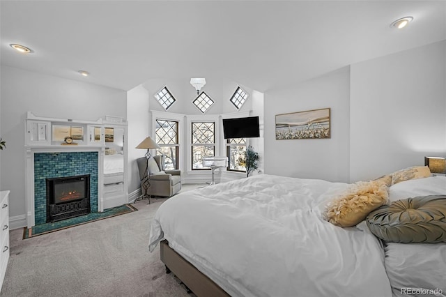 bedroom with lofted ceiling, recessed lighting, a fireplace, carpet flooring, and baseboards