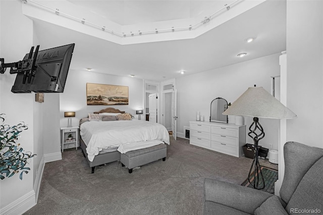 bedroom with dark colored carpet and baseboards