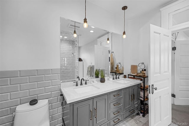 full bath featuring a sink, tile walls, toilet, and double vanity