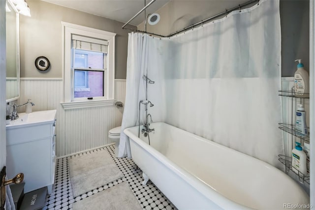 full bath with wainscoting, vanity, toilet, and tile patterned floors