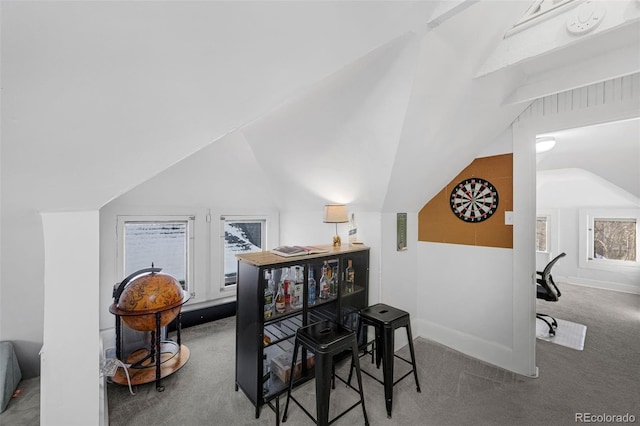 dining room with lofted ceiling, carpet, and baseboards