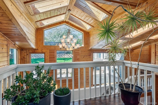 interior space featuring vaulted ceiling with skylight, wooden ceiling, and a notable chandelier