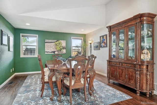 dining area featuring lofted ceiling, a wealth of natural light, and dark hardwood / wood-style floors