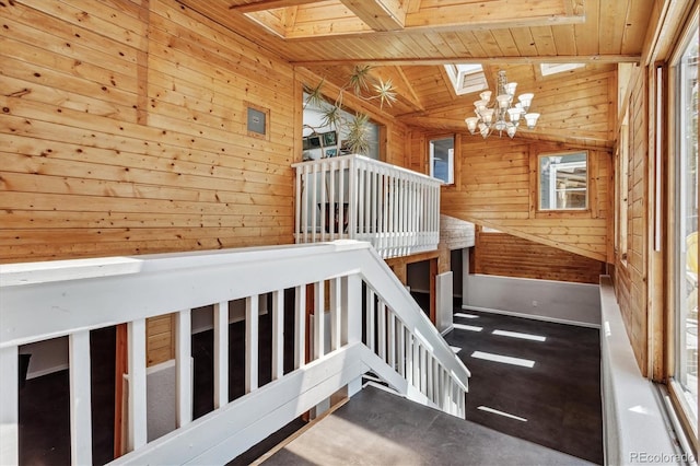 staircase with wooden walls, plenty of natural light, and wood ceiling