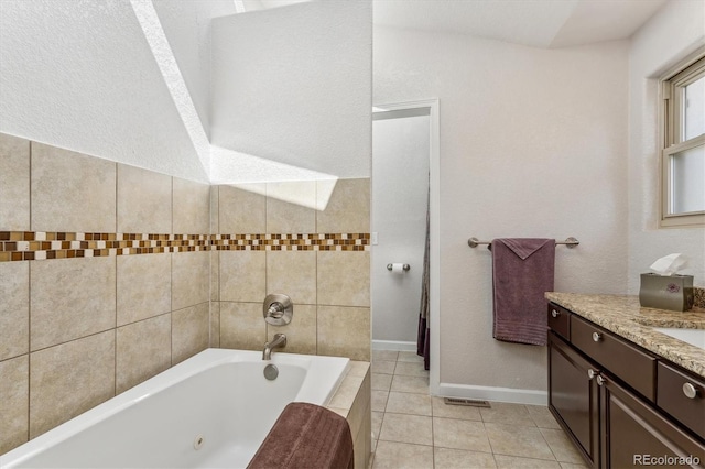 bathroom with tile patterned floors, a relaxing tiled tub, and vanity