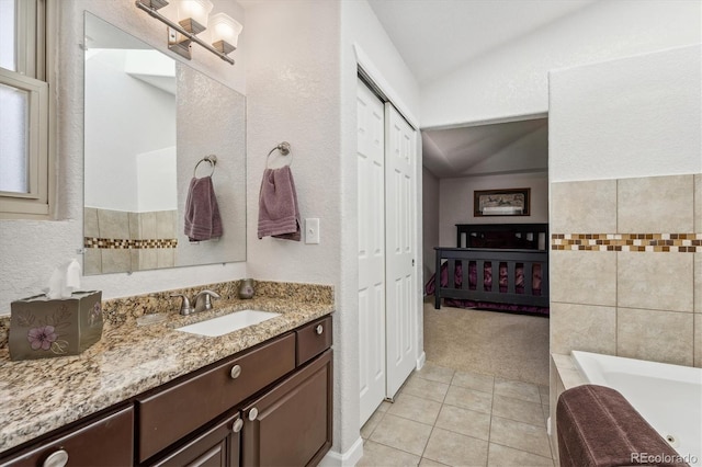 bathroom with vanity, a bath, tile walls, tile patterned flooring, and vaulted ceiling