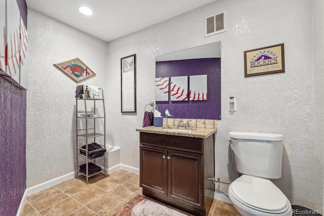 bathroom with vanity, tile patterned flooring, and toilet