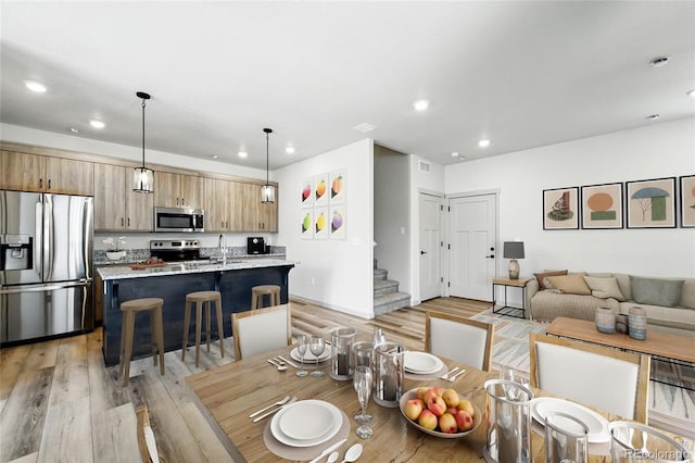 260 E 4th St, Berthoud, CO 80513 - dining space with light wood finished floors, recessed lighting, and stairway