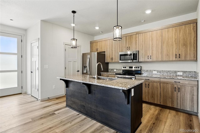 260 E 4th St, Berthoud, CO 80513 - kitchen featuring stainless steel appliances, a sink, a kitchen bar, light wood-type flooring, and recessed lighting