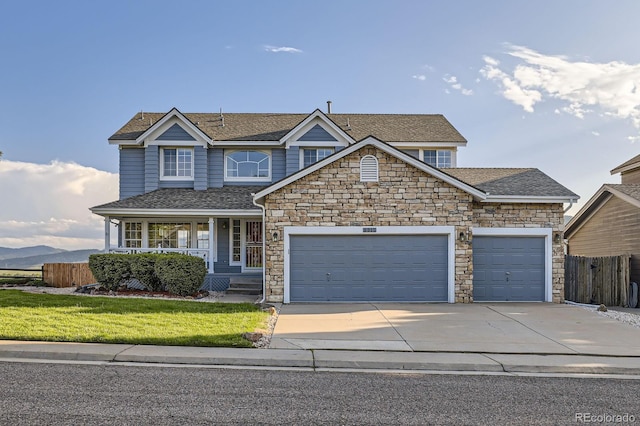 8915 S Field Ct, Littleton, CO 80128 - view of front of house featuring an attached garage, concrete driveway, a porch, and stone siding