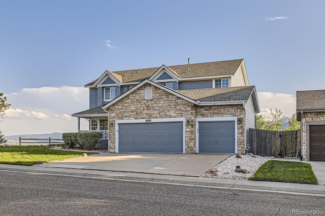 8915 S Field Ct, Littleton, CO 80128 - traditional-style house with stone siding, a garage, driveway, and roof with shingles