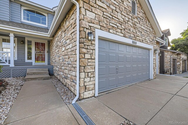 8915 S Field Ct, Littleton, CO 80128 - garage with driveway and a porch