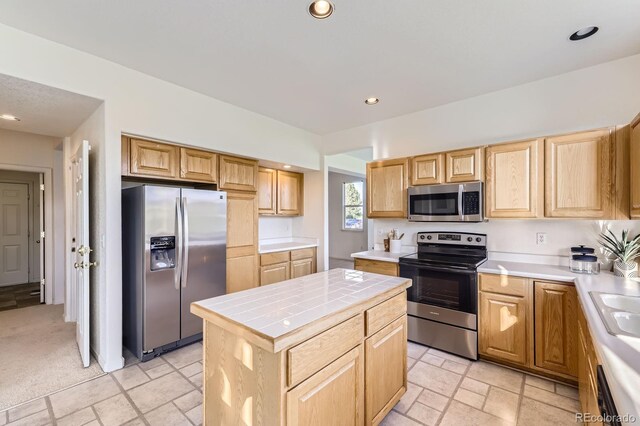 8915 S Field Ct, Littleton, CO 80128 - kitchen with stainless steel appliances, tile counters, light brown cabinets, recessed lighting, and a center island