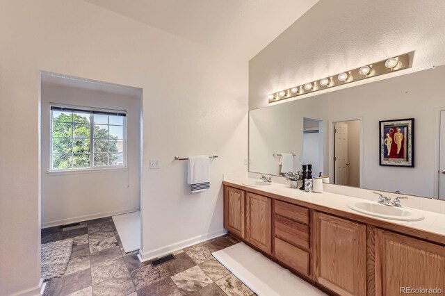 8915 S Field Ct, Littleton, CO 80128 - bathroom featuring double vanity and baseboards