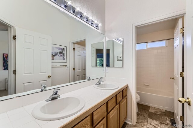 8915 S Field Ct, Littleton, CO 80128 - bathroom with toilet, double vanity, and shower / bathtub combination