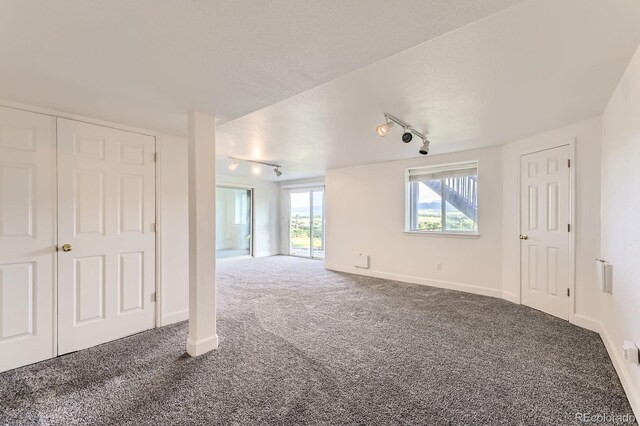 8915 S Field Ct, Littleton, CO 80128 - unfurnished living room featuring track lighting, carpet, and a textured ceiling