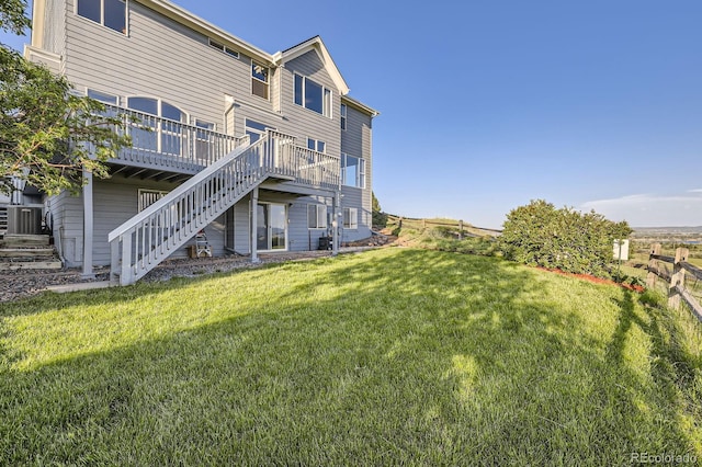 8915 S Field Ct, Littleton, CO 80128 - rear view of house featuring stairs, a wooden deck, and a yard