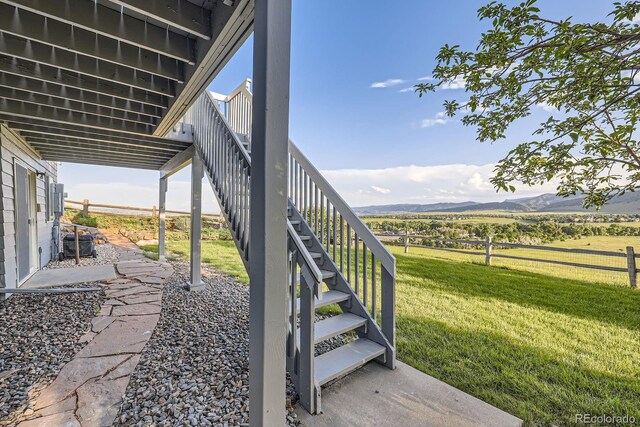 8915 S Field Ct, Littleton, CO 80128 - view of yard with stairway, a patio area, a mountain view, and a view of countryside
