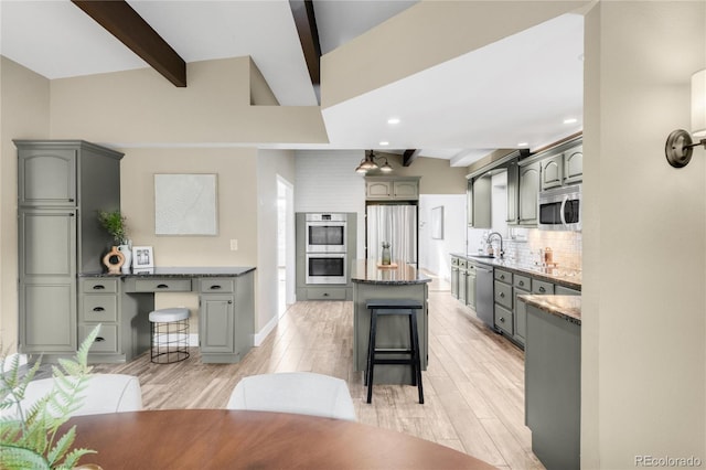 41 Skyline Dr, Wheat Ridge, CO 80215 - kitchen featuring stainless steel appliances, decorative backsplash, light wood-style flooring, a breakfast bar area, and a center island