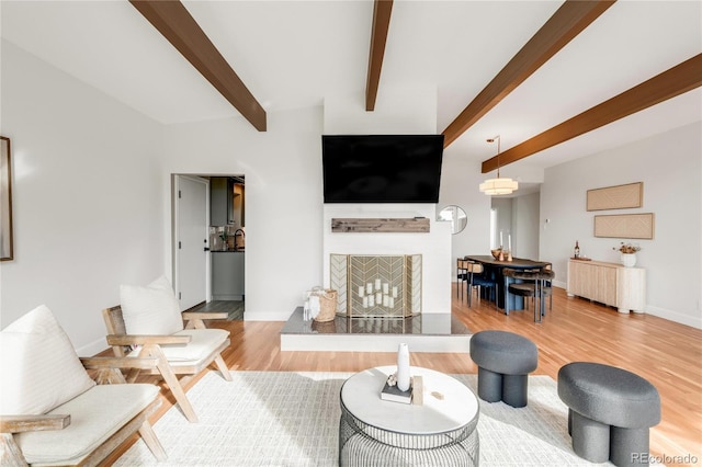 41 Skyline Dr, Wheat Ridge, CO 80215 - living room featuring beamed ceiling, wood finished floors, a fireplace with raised hearth, and radiator heating unit