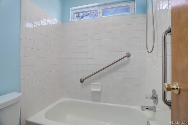 bathroom featuring toilet and tiled shower / bath combo