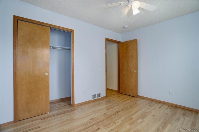 unfurnished bedroom featuring a closet, ceiling fan, light hardwood / wood-style floors, and a textured ceiling