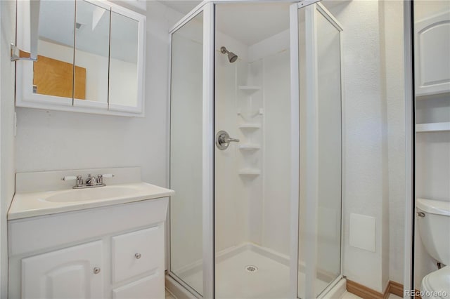 bathroom with toilet, an enclosed shower, and vanity