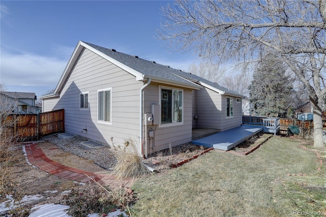 back of house with a deck and a lawn