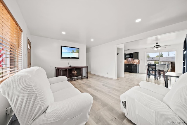 living room with recessed lighting, light wood-style flooring, ceiling fan, and baseboards