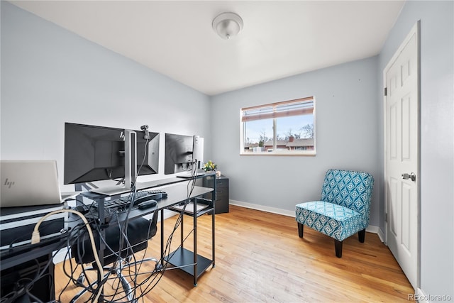 home office with baseboards and wood finished floors