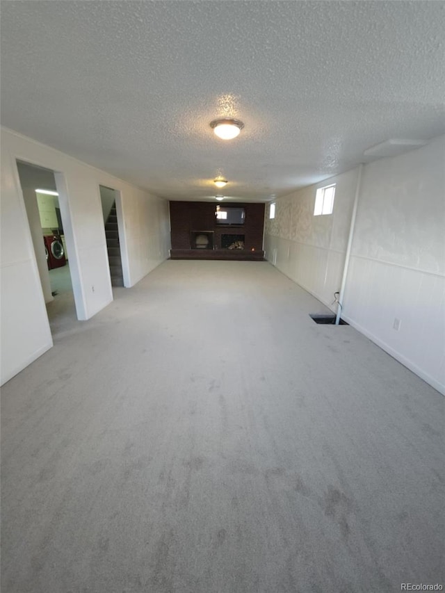 below grade area with stairs, a textured ceiling, and carpet