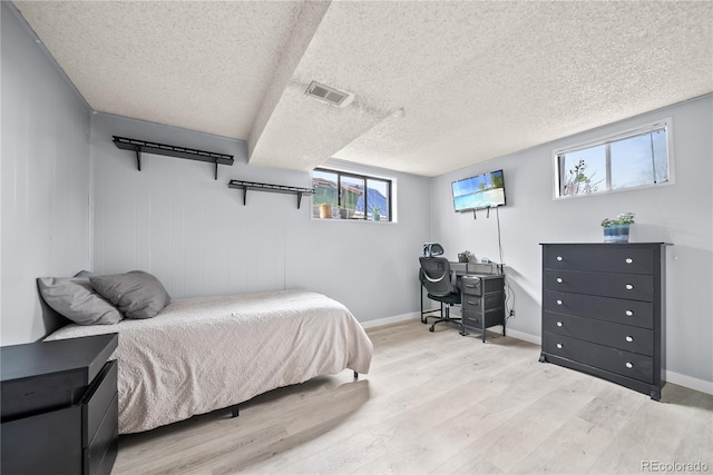 bedroom featuring baseboards, visible vents, multiple windows, and light wood-style flooring