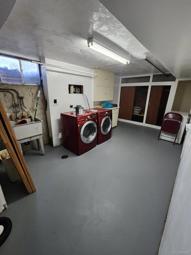 washroom featuring a sink, cabinet space, and washer and dryer