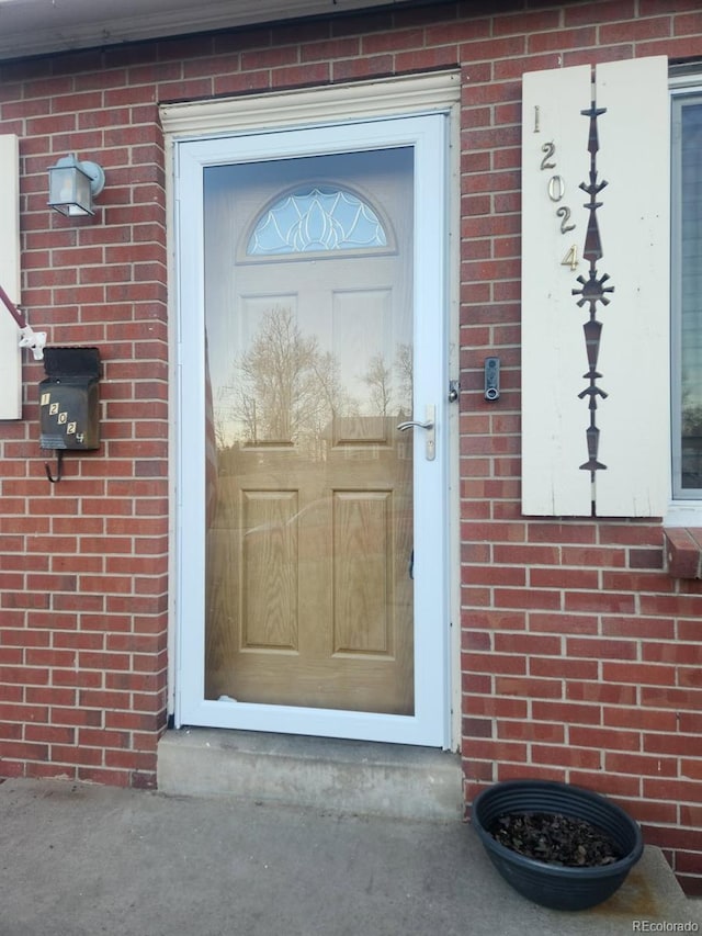 doorway to property featuring brick siding