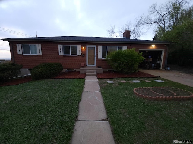 ranch-style house featuring an attached garage, driveway, a front lawn, and brick siding