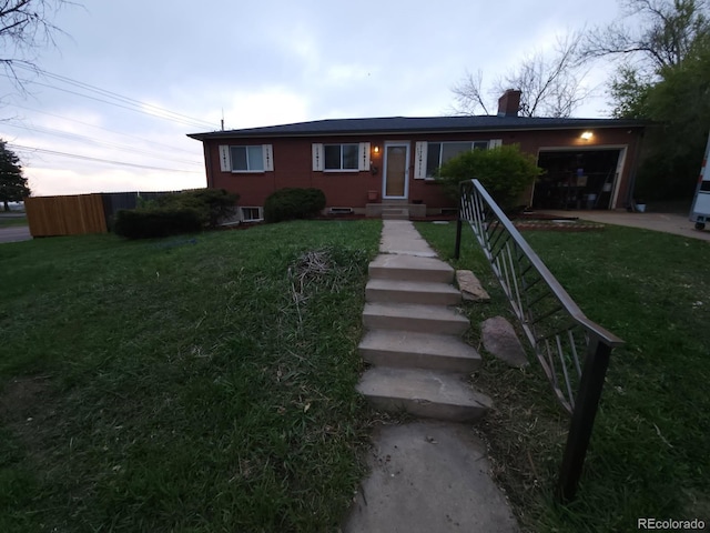 view of front facade with an attached garage, a front lawn, and a chimney