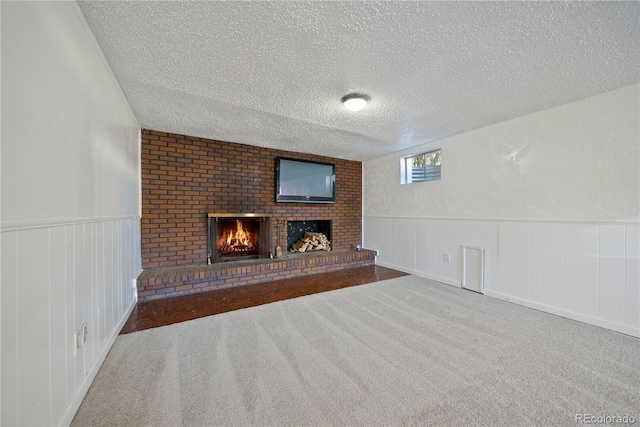 12024 W Maryland Dr, Lakewood, CO 80228 - unfurnished living room featuring a textured ceiling, carpet, a fireplace, a wainscoted wall, and a decorative wall