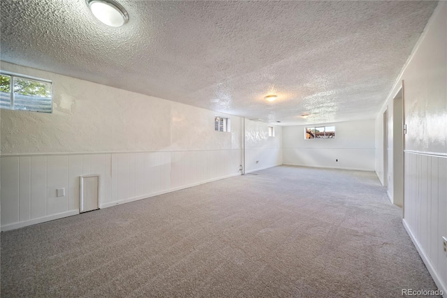 12024 W Maryland Dr, Lakewood, CO 80228 - basement featuring a textured ceiling, carpet flooring, and healthy amount of natural light