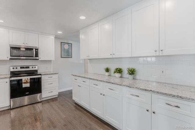 6059 Routt St, Arvada, CO 80004 - kitchen with stainless steel appliances, dark wood-type flooring, decorative backsplash, white cabinetry, and recessed lighting