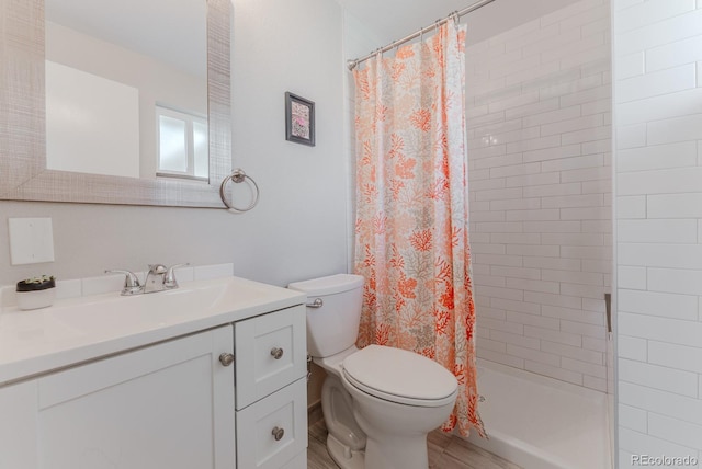 6059 Routt St, Arvada, CO 80004 - full bathroom featuring vanity, tiled shower, and wood finished floors