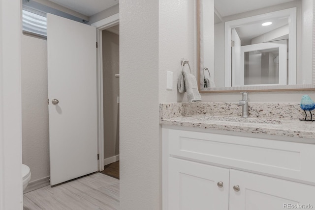6059 Routt St, Arvada, CO 80004 - bathroom featuring vanity and wood finished floors