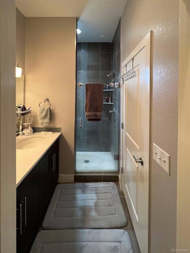 bathroom with vanity and a shower with door