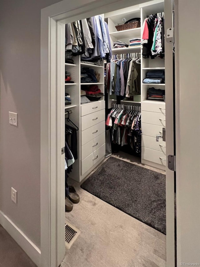 walk in closet featuring light colored carpet