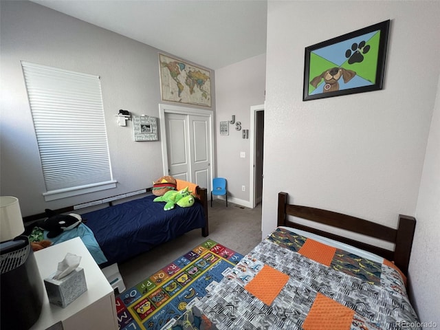 bedroom with carpet floors, a closet, and a baseboard heating unit